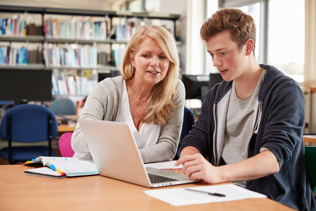 Student receiving tutoring in a library.
